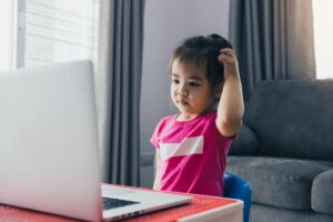 Asian child is dazed by the teachings of online students at home.