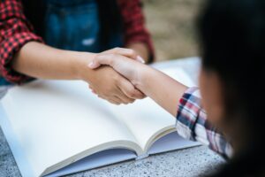 girls college student shake hand her friend at college park